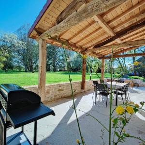 a wooden pergola with a table and chairs under it at Domaine Saint Loup - Gîte "Le Petit Loup" - 6 pers- 10min BEAUNE in Saint-Loup-Géanges