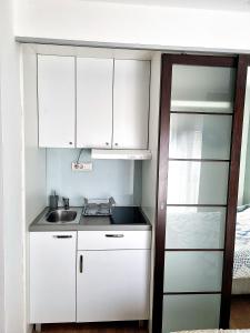 a small kitchen with white cabinets and a sink at Dixy 2 in Belgrade
