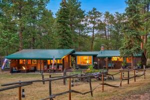 a cabin in the woods with a green roof at Cowboy Cabin Ranch in Colorado Springs