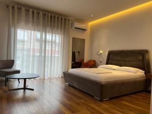 a bedroom with a bed and a table and a window at Skanderbeg Square Center Apartments in Tirana