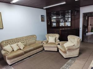 uma sala de estar com um sofá e duas cadeiras em Casa do Nonno na Montanha em Campos do Jordão