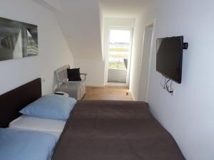 a bedroom with two beds and a flat screen tv at Sterntaucher in Hohwacht