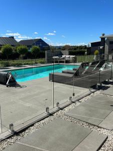 uma piscina com cadeiras e um escorrega em Titoki Grove em Cambridge