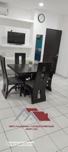 uma mesa preta e cadeiras num quarto com um relógio em COMODO DEPARTAMENTO VACACIONAL A 5 MIN. DEL MALECON em Mazatlán