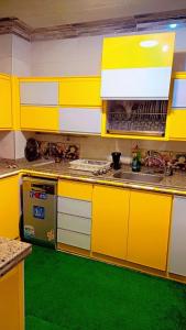 une cuisine avec des armoires jaunes et un sol vert dans l'établissement Nile Riviera in Mansoura, à Mansoura