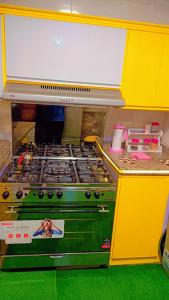 a yellow kitchen with a stove top oven at Nile Riviera in Mansoura in Mansoura