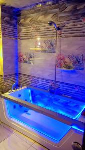 uma banheira com luzes azuis na casa de banho em Nile Riviera in Mansoura em Mansoura