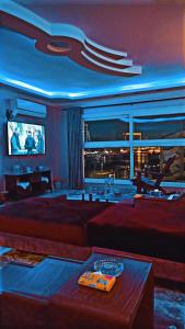 Nile Riviera in Mansoura في المنصورة: غرفة معيشة بها أريكة وتلفزيون