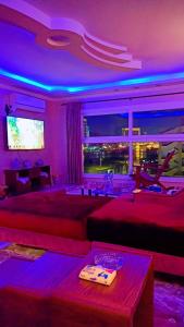 Nile Riviera in Mansoura في المنصورة: غرفة معيشة مع أضواء أرجوانية وأريكة