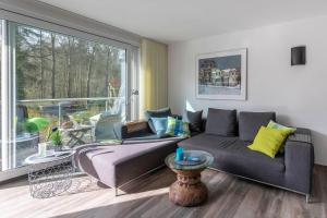 - un salon avec un canapé et une grande fenêtre dans l'établissement Strandhafer-Wulf-Weber, à Hohwacht