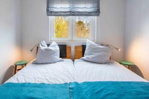 - 2 lits dans une chambre avec fenêtre dans l'établissement Strandhafer-Wulf-Weber, à Hohwacht