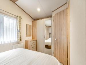um pequeno quarto com uma cama e um closet em Uk43577 - Oakdale em Begelly