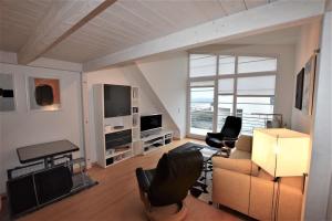 a living room with a couch and chairs and a television at Skandinavienblick-3-2-Flunderblick in Hohwacht