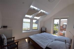a bedroom with a bed and two windows at Meeresblick-Deck-44-Haus-3-WE-44 in Hohwacht