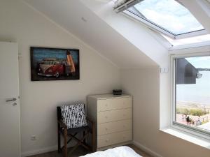 a bedroom with a window and a painting of a bus on the wall at Meeresblick-Deck-44-Haus-3-WE-44 in Hohwacht