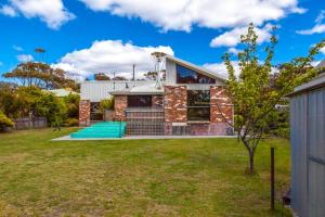 a brick house with a lawn in front of it at Beach Haven Scamander in Scamander