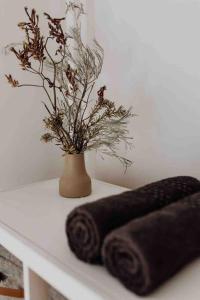 a white table with two towels and a vase with a plant at Beach Haven Scamander in Scamander +55 photos