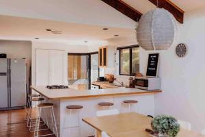a kitchen with a counter and some stools in it at Beach Haven Scamander in Scamander