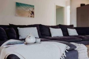 a living room with a couch and a table at Beach Haven Scamander in Scamander