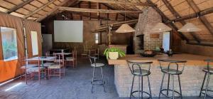 a room with a bar with stools and tables at Thornycroft lodge in East London