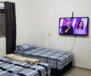 阿帕雷西達的住宿－Apartamento Aparecida do norte，客房设有两张床和一台墙上的电视。