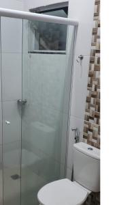 a bathroom with a toilet and a glass shower at Apartamento Aparecida do norte in Aparecida