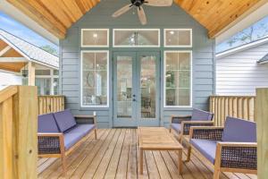 a porch with purple chairs and a wooden table at New 3BR Cottage with King Bed in Lafayette