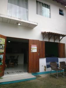 ein Gebäude mit einer Tür, 2 Stühlen und einem Tisch in der Unterkunft Hospedagem Pousada Fantasia Paraty in Paraty