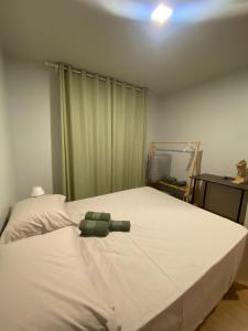 a stuffed animal laying on a bed in a bedroom at Residencial Cayenne in Caxias do Sul