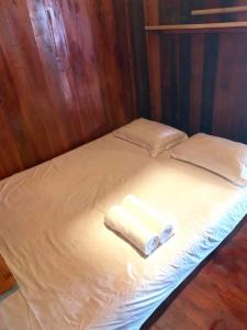 Una cama con dos toallas encima. en Sapa Rosie Stilt House en Sa Pa