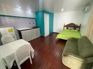 a living room with a green couch and a bed at Apartamentos Zamora in Puerto Limón