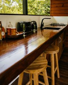 a kitchen with a counter and two stools at Cape Trib Farm in Cape Tribulation