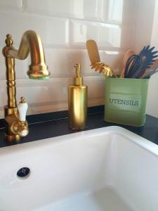 un lavandino in bagno con rubinetto d'oro e lavandino di AN Deluxe Suites ad Ancona