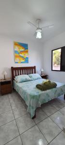 um quarto com uma cama e uma ventoinha de tecto em Cantinho do Boris l em Ubatuba