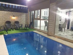 una piscina en una casa con sillas y mesa en la sublime, en Taghazout