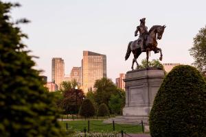 een standbeeld van een man op een paard in een park bij The Ritz-Carlton, Boston in Boston