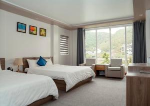 a hotel room with two beds and a window at Catba Central Hotel 2 in Cat Ba