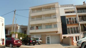 a white building with cars parked in front of it at Apartamentos Estartit Park in L'Estartit