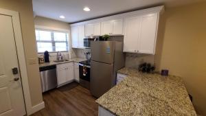 a kitchen with white cabinets and a stainless steel refrigerator at 3BR Walk-In with Loft - Pool and Hot Tub - FREE TICKETS INCLUDED - PARA in Branson
