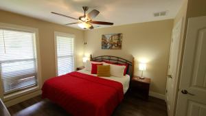 a bedroom with a red bed and a ceiling fan at 3BR Walk-In with Loft - Pool and Hot Tub - FREE TICKETS INCLUDED - PARA in Branson +18 photos