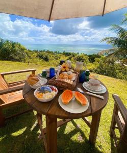 una mesa de picnic con comida y vistas al océano en Sungazer, en Arraial d'Ajuda