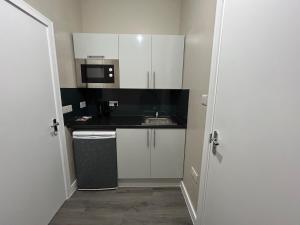 a small kitchen with a sink and a microwave at studio in Ilford