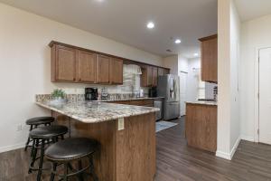 a kitchen with wooden cabinets and a large island with bar stools at 3BR Walk-In - Close to Attractions - FREE TICKETS each day you stay - RL4-2 in Branson