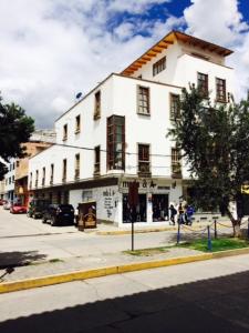 a white building on the corner of a street at La Aurora in Huaraz