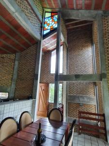uma sala de jantar com uma mesa de madeira e um vitral em Casa Vitral - Em condomínio fechado - Aldeia/PE em Pau dʼAlho