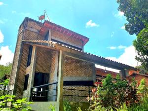 um edifício de tijolos com uma varanda em cima em Casa Vitral - Em condomínio fechado - Aldeia/PE em Pau dʼAlho