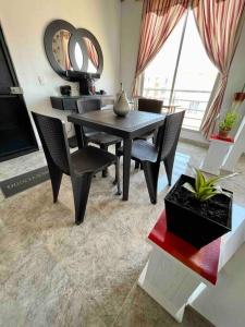 a dining room with a black table and chairs at Acogedor apartamento en conjunto residencial in Soledad