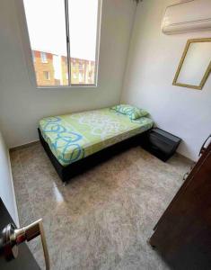Cama pequeña en habitación con ventana en Acogedor apartamento en conjunto residencial, en Soledad