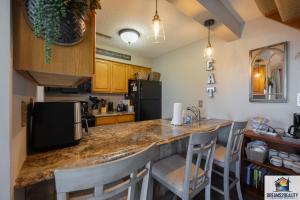 a kitchen with a counter with chairs and a refrigerator at Lake View! Walk-In 3 BR Condo - Outdoor Pool - FREE TICKETS INCLUDED - TRH6-6 in Branson
