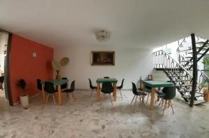 a room with two tables and chairs and a staircase at Casa San Antonio in Aguascalientes